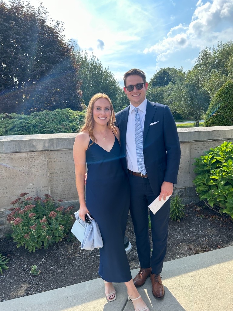 Laura and Andrew dressed for a wedding in navy formalwear