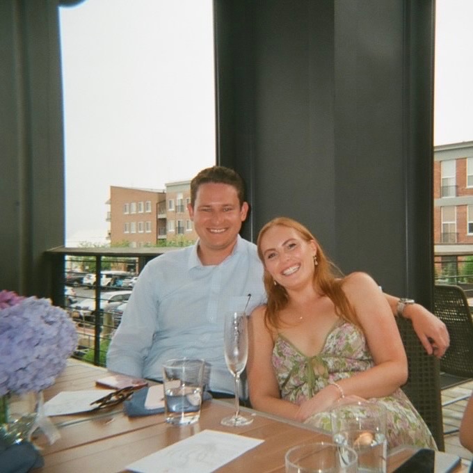 Laura and Andrew seated together at an outdoor table
